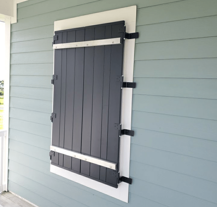 Functional colonial storm shutter deployed over a window